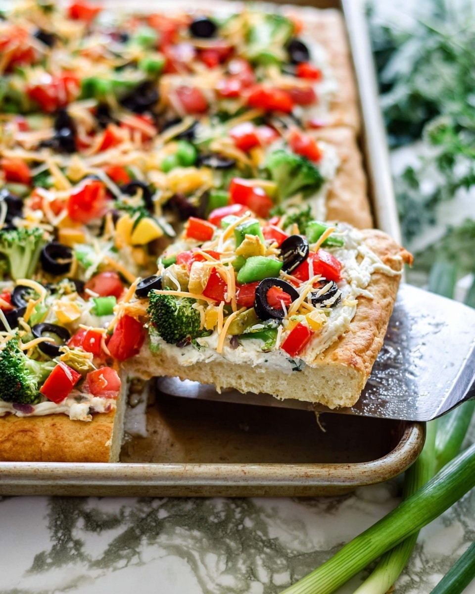 A thick square slice of vegetable pizza is being lifted on a metal spatula from a white baking tray. The pizza has a thick, golden-brown crust as the bottom layer, followed by a creamy white cheese spread. On top, there are colorful chopped vegetables including green broccoli florets, red and yellow bell peppers, diced red tomatoes, and sliced black olives scattered across. Sprinkled cheese shreds in light yellow and white hues are spread unevenly over the vegetables. The background surface is a white marbled texture with green onions partially visible next to the tray. Photo taken with an iphone --ar 4:5 --v 7