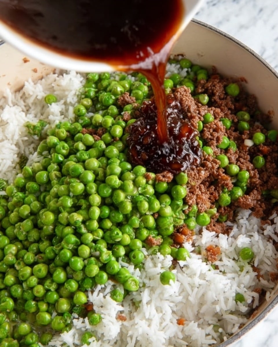 A close-up view of a white pot filled with three main layers: a base layer of cooked ground meat mixed with some small diced vegetables in brown and orange shades, a top layer of bright green peas mostly covering white cooked rice grains, and a dark brown sauce being poured over the rice and peas from above. The peas have a smooth, round texture and contrast with the fluffy white rice and the coarse ground meat. The surface under the pot is a white marbled texture. photo taken with an iphone --ar 4:5 --v 7