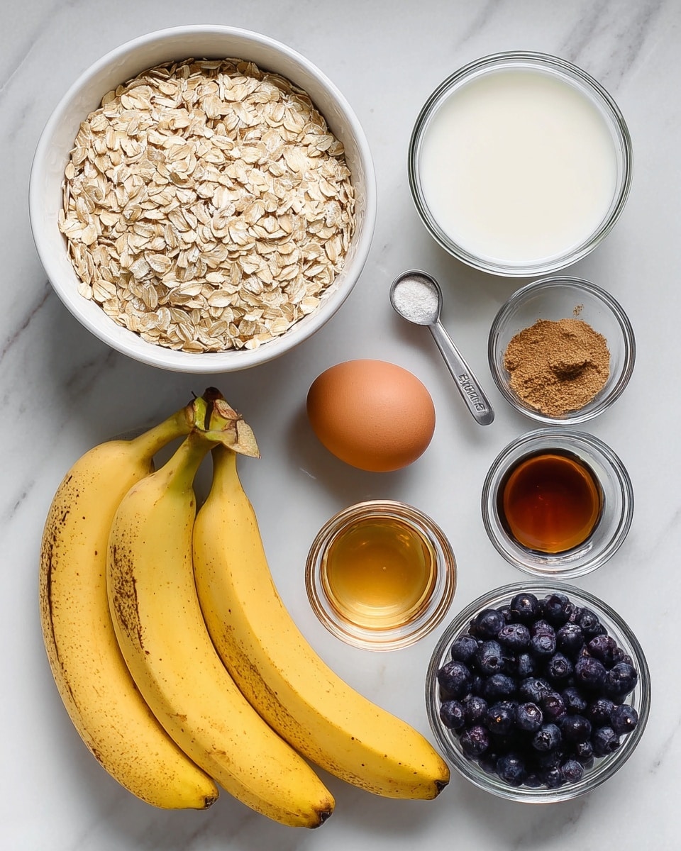 The image shows eight food ingredients neatly arranged on a white marbled surface. On the left, there is a white bowl filled with light tan rolled oats. Below the bowl, three yellow bananas with slight brown spots lay side by side. To the right of the bananas, a single brown egg is placed next to a silver measuring cup holding dark frozen blueberries. Above these, six small containers form two rows: a glass filled with white milk, a white bowl with amber honey, a small clear bowl containing brown liquid vanilla extract, and another small clear bowl with white baking soda and brown cinnamon powder mixed together. The photo taken with an iphone --ar 4:5 --v 7