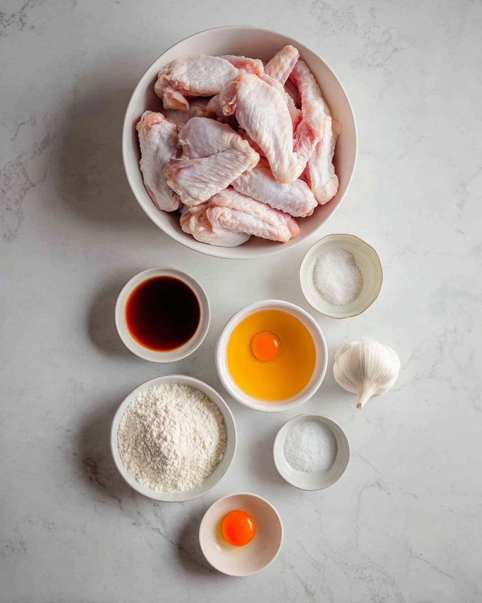 A white bowl full of raw chicken wings with a pink and light beige color is placed at the top center on a white marbled surface. Below it, in a scattered line, there are small white bowls; one with a dark brown liquid, another with clear liquid, a larger one filled with white powder, a smaller bowl with coarse white powder, a tiny bowl with a bright orange yolk, and a small white dish with salt. A whole white garlic bulb sits near the top right of the chicken bowl. The arrangement is neat, showing all ingredients clearly. Photo taken with an iphone --ar 4:5 --v 7