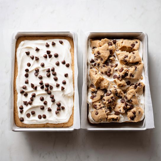 The image shows two white parchment-lined square pans side by side on a white marbled surface. The pan on the left has three visible layers: a golden brown cookie dough base at the bottom, a thick, smooth white marshmallow layer in the middle, and scattered dark brown chocolate chips evenly spread on top. The pan on the right shows the same layers but the top cookie dough layer is broken into large uneven pieces, partially covering the white marshmallow layer and chocolate chips beneath. The texture of the cookie dough pieces looks soft and slightly crumbled, while the marshmallow layer remains smooth and the chocolate chips are semi-melted and shiny. Photo taken with an iphone --ar 4:5 --v 7