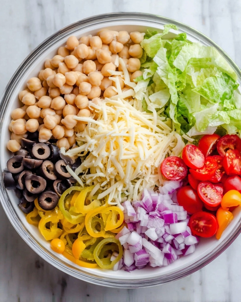 A clear white bowl filled with different salad ingredients arranged in separate sections. On the top right, there are round beige chickpeas. Next to them on the left, shredded pale yellow cheese. Below the cheese on the left, black sliced olives. Below the olives, thin yellow pepper rings. Next to the pepper rings on the right, small diced purple onions. On the right side of the bowl, fresh light green lettuce leaves. Below the lettuce, bright red and orange cherry tomato halves. The bowl is placed on a white marbled surface. photo taken with an iphone --ar 4:5 --v 7