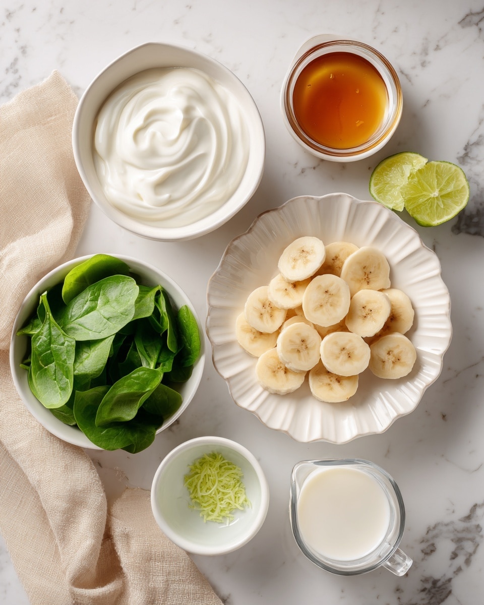 The image shows a white fluted plate in the center filled with round banana slices layered in a small pile. Around it are seven small white bowls and dishes arranged neatly on a white marbled surface. Starting from the top left, a bowl of thick white yogurt with smooth swirls, next to it a small bowl with amber honey, and two small plates to the right holding fresh lime halves and a small pile of bright green lime zest. Below these is a glass measuring cup with white coconut milk, and next to it a small white bowl filled with light green lime juice. At the bottom left, a white bowl holds fresh green spinach leaves with a soft texture and natural folds. A beige cloth napkin is slightly folded on the lower left edge. photo taken with an iphone --ar 4:5 --v 7