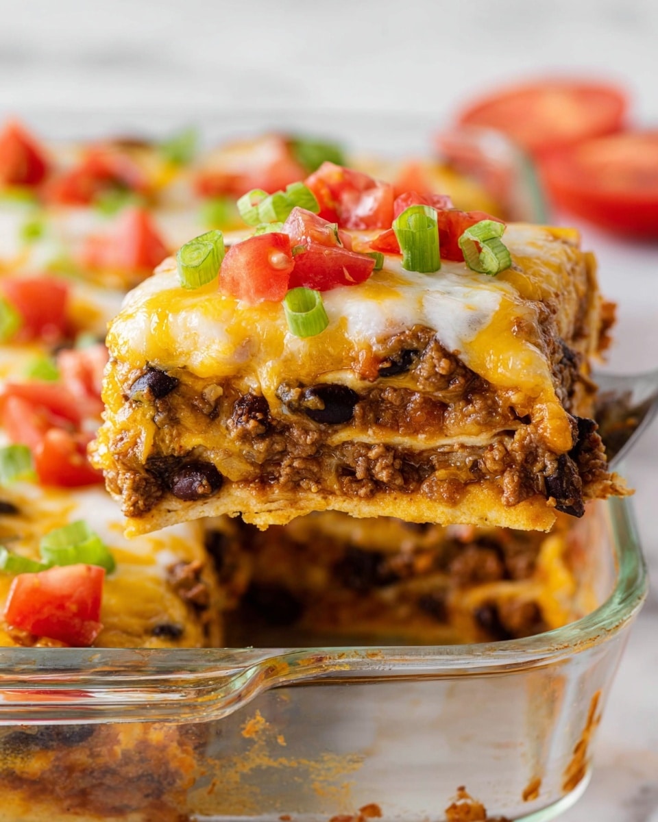 A close-up view of a square slice of layered casserole being lifted, showing at least five thick layers, each layer containing ground meat mixed with black beans and melted cheese. The top layer is fully covered with melted cheese, garnished with small diced red tomatoes and chopped green onions. The casserole is in a clear glass dish placed on a white marbled surface, with other slices and fresh tomato pieces visible in the blurry background. Photo taken with an iphone --ar 4:5 --v 7