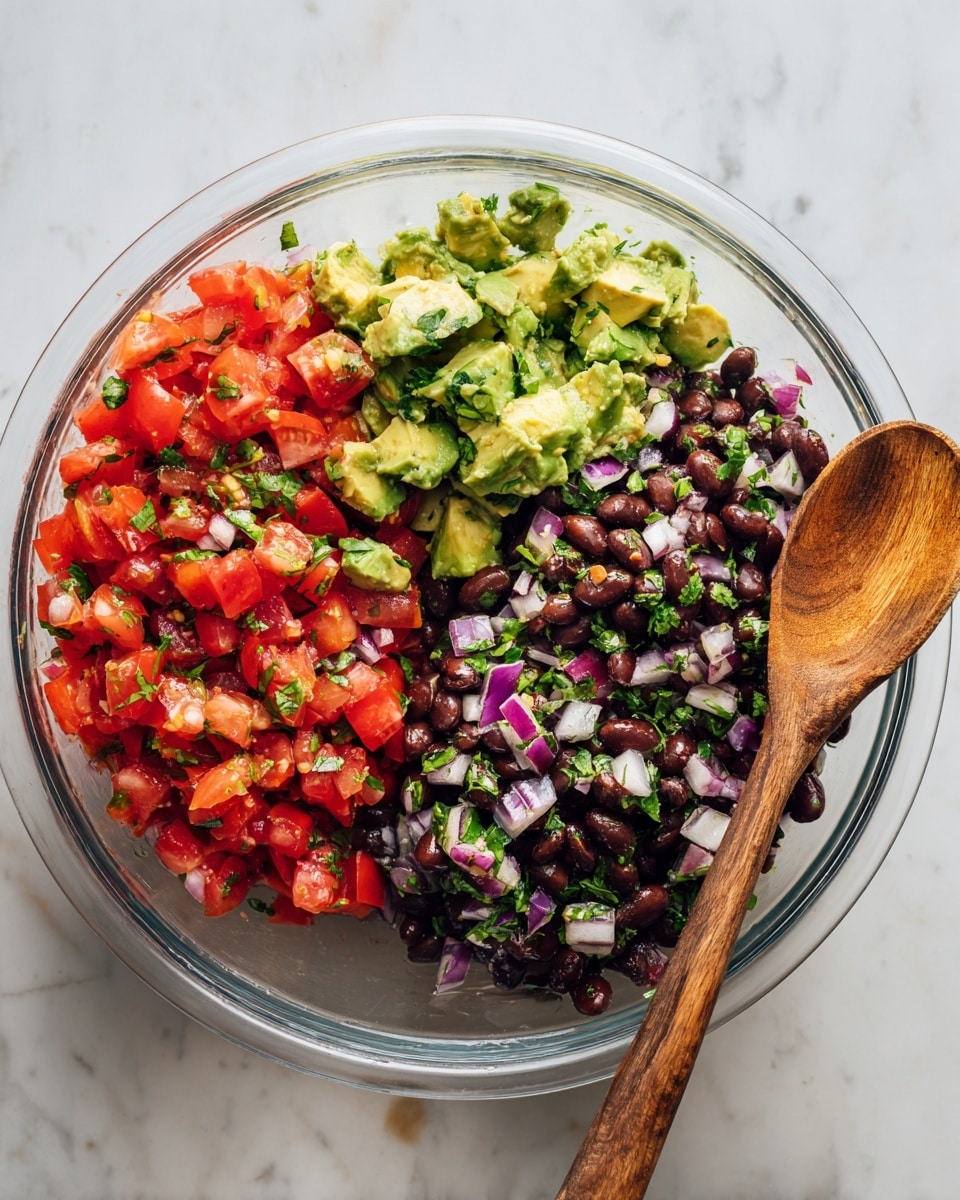 In a clear glass bowl on a white marbled surface, there is a colorful mix of ingredients before and after being stirred. On the left, separate layers show bright red tomato pieces, green avocado chunks, light purple onions, and dark black beans topped with fresh green herbs. On the right, all the ingredients are mixed together, showing a rich, varied texture of black beans, chopped tomatoes, avocado, onions, and herbs, with a wooden spoon resting in the bowl. The lighting highlights the fresh colors and textures of the food. Photo taken with an iphone --ar 4:5 --v 7