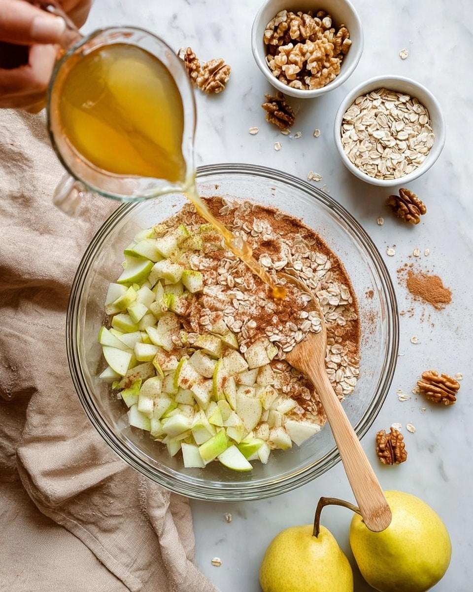 A clear glass bowl sits on a white marbled surface, filled with a mixture of sliced light green pear pieces, raw oats, and a sprinkling of cinnamon powder creating a light brown swirl pattern on the surface. A wooden spoon rests inside the bowl at the right side, partly covered with the mixture. A woman's hand is pouring golden honey from a small clear measuring cup into the bowl. Around the bowl are scattered oat flakes and whole walnut halves, with two whole yellow pears at the bottom right. Two small white bowls sit near the top, one filled with finely chopped walnuts and the other with ground cinnamon. A beige cloth napkin is placed under the left side of the bowl photo taken with an iphone --ar 4:5 --v 7