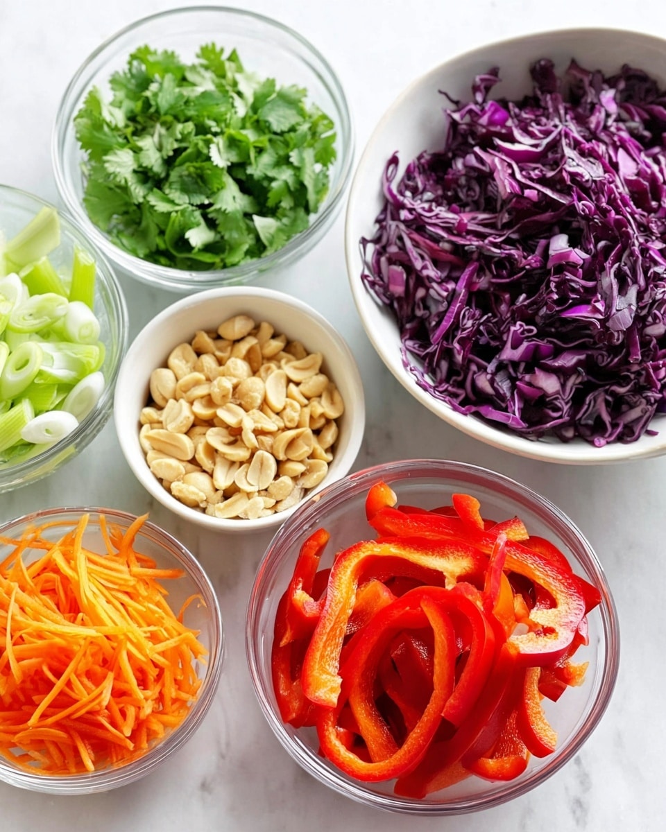 The image shows a group of six small white bowls set on a white marbled surface, each filled with different fresh ingredients. Starting from the top right, there is a bowl filled with dark purple shredded cabbage with a firm and slightly shiny texture. Below it to the right, a bowl holds chopped cilantro leaves, bright green and leafy. At the bottom right, a bowl contains chopped peanuts, cream-colored and slightly rough. To the bottom left, a bowl is filled with sliced green onions, green with white ends and smooth texture. Near the bottom left, there is a clear bowl filled with thin orange carrot sticks, finely shredded and crisp. In the center, a clear bowl holds vibrant red bell pepper strips, glossy and thick, arranged loosely within the bowl. The photo is taken with an iphone --ar 4:5 --v 7