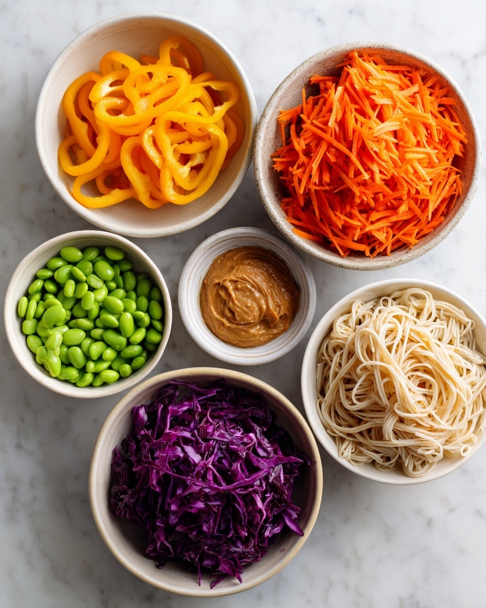 The image shows six white bowls arranged on a white marbled surface. Starting from the top center and moving clockwise: a bowl filled with bright orange sliced carrots, a small bowl with light brown peanut sauce that has a smooth texture, a bowl with light beige rice noodles loosely piled, a small bowl with shredded bright orange carrots, a bowl with deep purple shredded cabbage, and a bowl with vibrant green edamame beans. On the top left, there’s a bowl of bright yellow sliced bell peppers. Each bowl has neatly arranged ingredients, creating a colorful and fresh look. Photo taken with an iphone --ar 4:5 --v 7