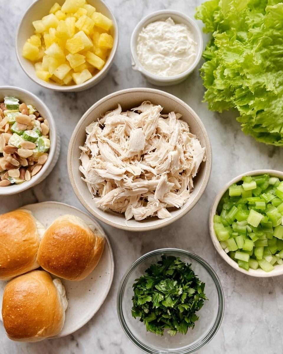 The image shows several bowls and plates with ingredients arranged on a white marbled surface. At the center is a bowl with shredded white chicken pieces. Above it, to the left is a white bowl filled with diced yellow pineapple, and to the right, a white bowl filled with chopped green celery. To the right of the chicken bowl, there is a smaller clear bowl with a white creamy substance, and below it another bowl filled with chopped green herbs. Below the chicken, there is a white bowl with sliced almonds. On the left side, three golden brown round rolls are placed on a white plate. A small white dish with a damp beige sauce is above the rolls, and in the upper right corner, fresh green butter lettuce leaves are partially visible. Photo taken with an iphone --ar 4:5 --v 7
