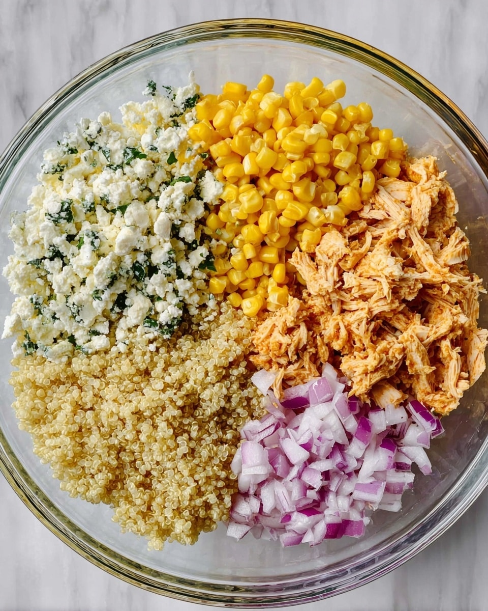 A clear glass bowl with five separate layers of ingredients arranged side by side inside. On the top left is crumbled white cheese with green herbs, next to it on the top right is bright yellow corn kernels. Below the corn, on the right side, is shredded light orange chicken. On the bottom left is a pile of cooked quinoa with a pale beige color, and next to the cheese on the far left is finely chopped red onion with a mix of white and purple color. The bowl sits on a white marbled surface. photo taken with an iphone --ar 4:5 --v 7