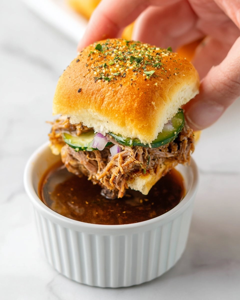 A woman's hand is holding a small square sandwich with a golden brown top bun sprinkled with green herbs and small bits of seasoning. Inside the sandwich, there are layers of shredded brown meat, slices of green cucumber, and small purple onion pieces. The sandwich is being dipped into a white ridged ramekin filled with dark brown sauce that has a shiny, liquid texture. The background and surface are white marbled texture. photo taken with an iphone --ar 4:5 --v 7