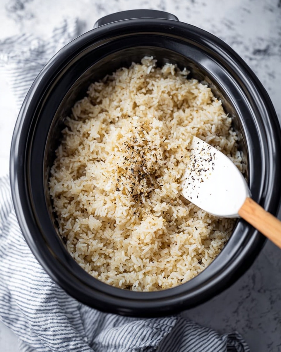 A black electric rice cooker with cooked rice inside, the rice is fluffy and light beige with some darker bits mixed in, giving it a slightly toasted look; a white plastic rice paddle with black pepper flakes on it is resting inside the rice cooker against the side, the scene is set on a white marbled surface with a striped blue and white cloth placed nearby photo taken with an iphone --ar 4:5 --v 7