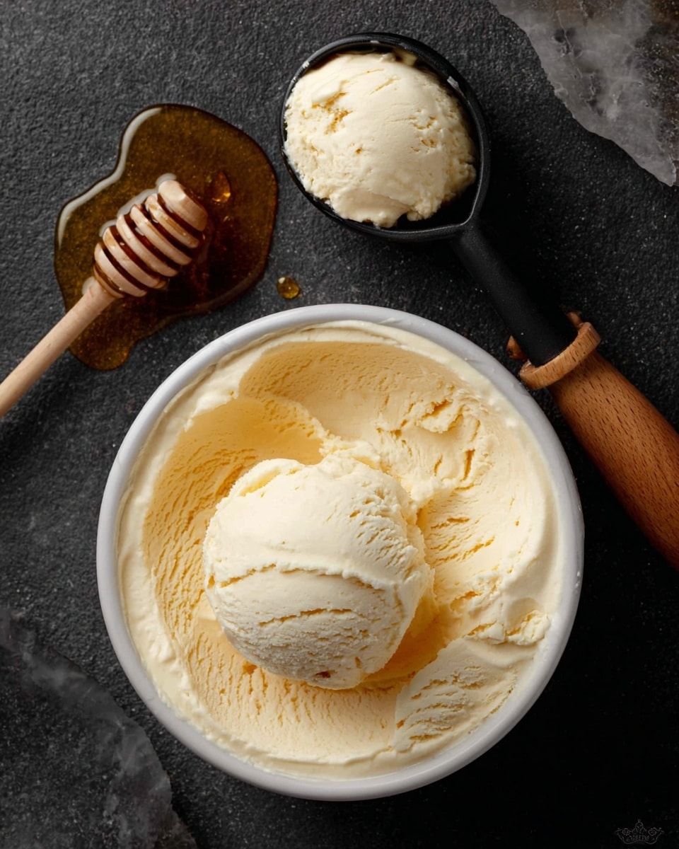 The image shows a white round container filled with smooth creamy pale yellow vanilla ice cream, with a scoop already taken out from the middle. Above, a black ice cream scoop with a wooden handle holds a rounded scoop of the same ice cream. To the top left, a wooden honey dipper rests on a small puddle of golden honey. The whole scene is set on a dark textured surface that should be imagined as a white marbled texture. photo taken with an iphone --ar 4:5 --v 7