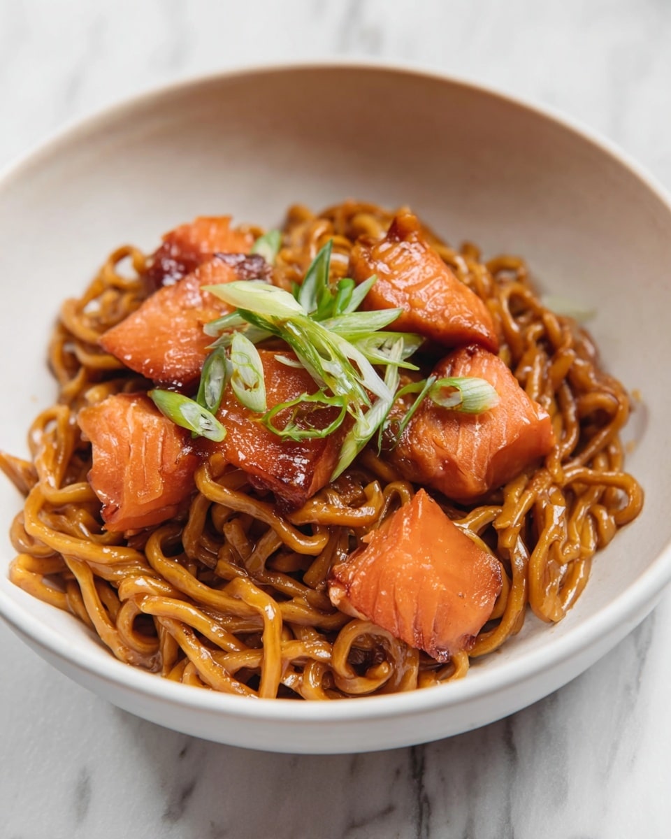 A white bowl holds a dish with a base layer of thick, glossy brown noodles, slightly twisted and coated in sauce. On top of the noodles, there are several pieces of orange salmon, cooked with a smooth texture. Bright green slices of scallions are sprinkled over the salmon and noodles, adding a fresh look. The bowl sits on a white marbled surface. photo taken with an iphone --ar 4:5 --v 7