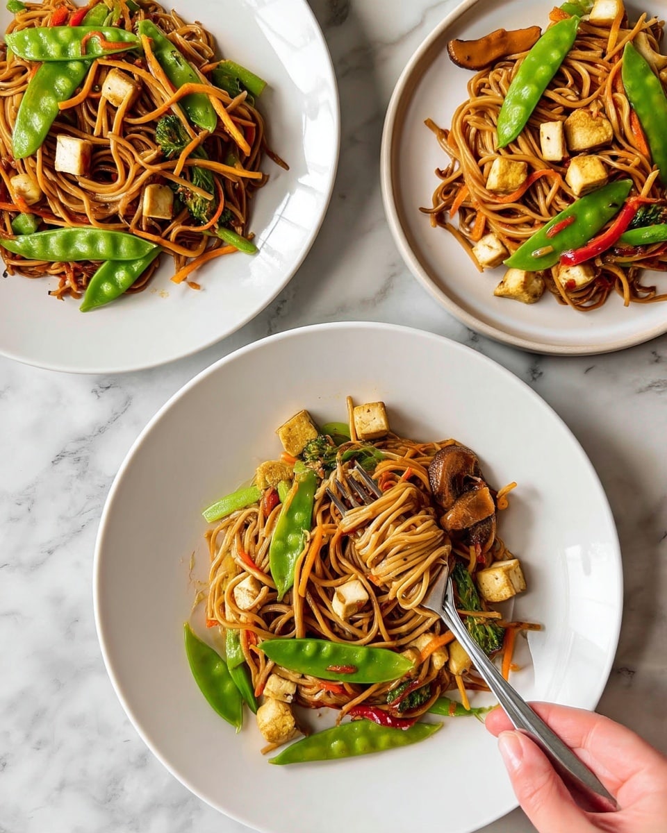 Three white plates each hold a serving of stir-fried noodles mixed with small tofu cubes, sliced mushrooms, green snow peas, thin carrot strips, and red chili pieces. The noodles are light brown with a slight shine from the sauce, layered with bright green snow peas on top and scattered vegetables throughout. One plate in the center has a metal fork resting in the noodles, and a woman's hand is lifting some noodles with the fork. The background is a white marbled surface. photo taken with an iphone --ar 4:5 --v 7