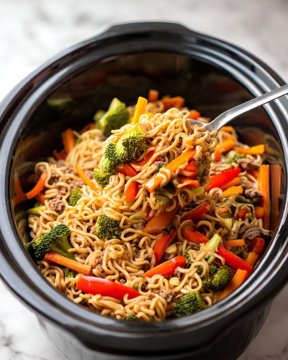 A close-up view of a black slow cooker filled with cooked noodles mixed with thin orange carrot sticks, small green broccoli florets, bright red bell pepper strips, and small pieces of cooked meat, all mixed and lifted by a metal spoon. The noodles are light brown, twisted and soft, with vegetables and meat scattered evenly throughout. The broccoli pieces are distinctly green and chunky, while the carrots appear crisp and long. The surface under the cooker is a white marbled texture. Photo taken with an iphone --ar 4:5 --v 7